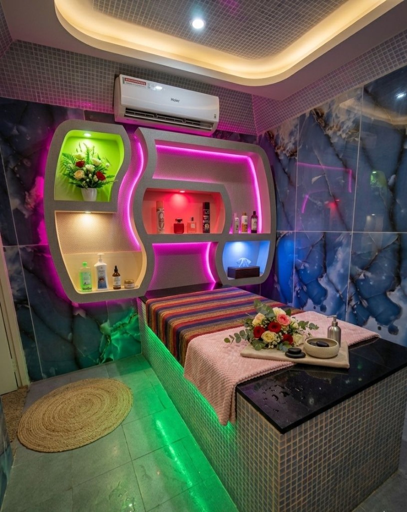 Luxury treatment room with marble walls, mosaic-tiled massage table and rose display